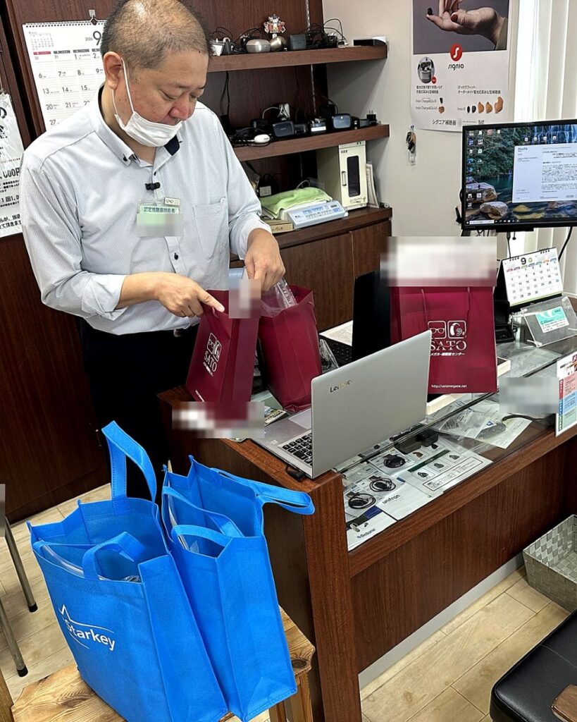 店内で補聴器のお渡し準備を進めるSATOメガネ補聴器センターのスタッフ